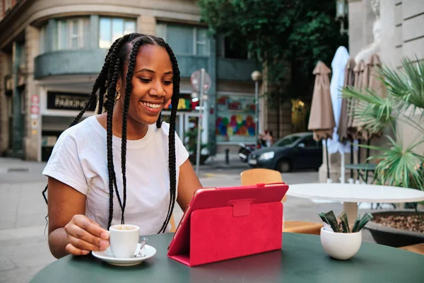 Mujer latina joven trabajando al aire libre con una tableta digital y un café —  Fotos de Stock