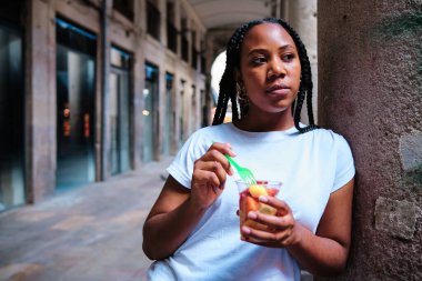 Dışarıda sağlıklı meyve yiyen genç bir kadın.