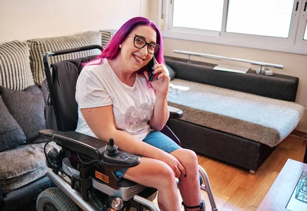 Kvinna i rullstol använder smartphone hemma — Stockfoto