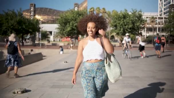 Fiatal göndör haj nő séta Barcelonas kikötő — Stock videók