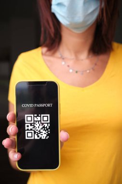 Akıllı telefondan pasaport sahibi tanınmayan bir kadın. Coronavirüs salgını konsepti.