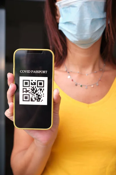 Akıllı telefondan pasaport sahibi tanınmayan bir kadın. Coronavirüs salgını konsepti.