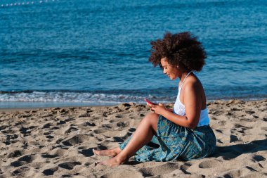 Akıllı telefon kullanan kıvrımlı bir kadın.