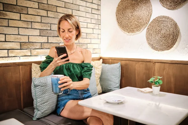 Hubená žena pomocí smartphonu vyfotit zdravé smoothie — Stock fotografie