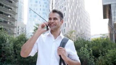 Modern şehir bölgesinde akıllı telefon kullanan genç yaratıcı iş adamı