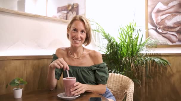 Young attractive woman drinking healthy smoothie at bar — Stock Video