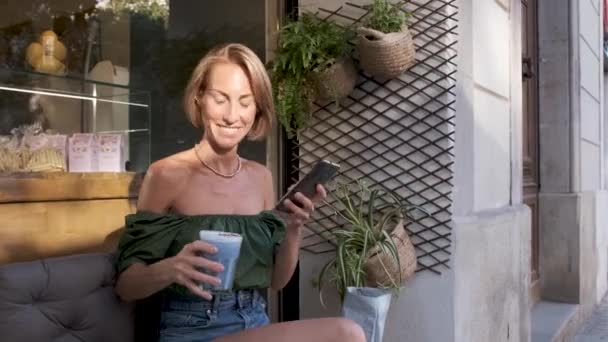 大人のフィット女性は屋外でスムージーを飲み、ソーシャルネットワークのために自撮り-ウイルス動画 — ストック動画