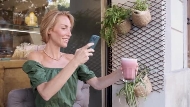 Adult fit woman using smartphone and smoothie for viral video - influencer concept — Stock Video