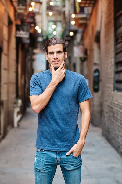 Genç beyaz adam kameraya bakıyor.