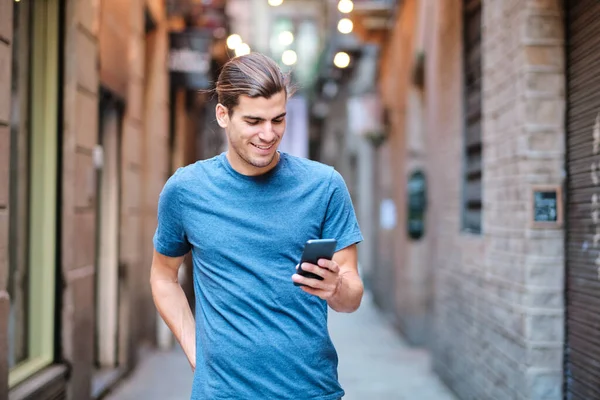 Young handsome model using smartphone at El Borne district - Barcelona —  Fotos de Stock