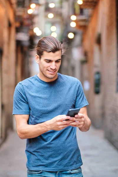 Vertical photo of young man looking at mobile phone at El Borne - Barcelona —  Fotos de Stock