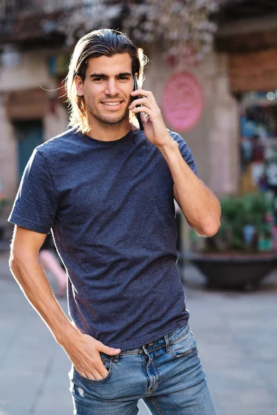 Modelo superior joven con el pelo suelto usando un teléfono inteligente —  Fotos de Stock