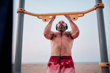 Sahilde beden eğitimi egzersizi yapan bir sporcu..