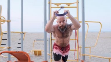 Plajda lastik bantla atletizm eğitimi almış. Jimnastik konsepti.