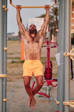 Atletik adam açık havada jimnastik yaparken egzersiz yapıyor..