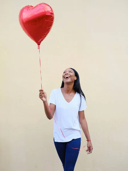 Jeune femme américaine africaine tenant un ballon en forme de coeur. — Photo