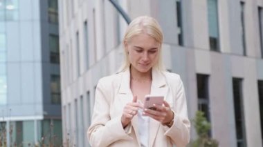 Finans bölgesinde akıllı telefon kullanan genç bir iş kadını - şirket yaşam tarzı konsepti