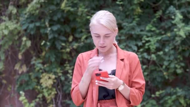 Ung vuxen kvinna förvånad och orolig för ett meddelande i sin smartphone — Stockvideo