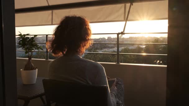 Unrecognizable woman with anxiety and mental health problems alone at balcony at sunset - health and medicine concept — Stock Video