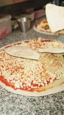 Yetenekli bir şefin siyah eldivenli ellerini yakından çek. Pizzanın üzerinde patlıcan dilimlerini mozzarella peynirli dikkatlice düzenle.