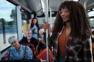 Bir şehir otobüsünde gidip gelen çeşitli yolcular elinde tırabzan tutan ve gülümseyen genç bir kadın görmüşler.