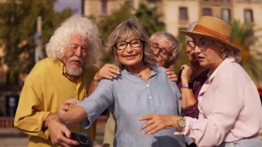 Dört mutlu yaşlı arkadaştan oluşan bir grup akıllı telefonla selfie çekmek için bir araya geliyor. Aktif yaşlılar dışarıda tatilde eğleniyor.