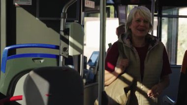 Mutlu yaşlılar halk otobüsüne biniyor. Sakallı yaşlı bir adam, uçaktaki elektronik makinede biletini onaylıyor.