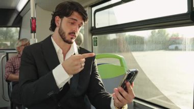 Akıllı telefonuyla yaptığı video görüşmesi sırasında işaret diliyle iletişim kuran iyi giyimli bir iş adamı.