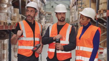 Çeşitli lojistik çalışanları bir dağıtım merkezinde envanter yönetimi için barkod tarayıcıları kullanarak nakliye işlerinde işbirliği yapıyorlar.