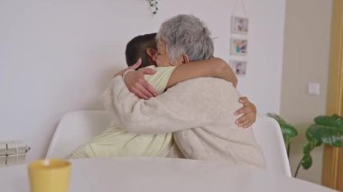 Latin bir torunla büyükannesi arasındaki aşk anı. Şefkatle sarılırlar ve öpüşürler, derin aile sevgisini ve mutluluğu ifade ederler.