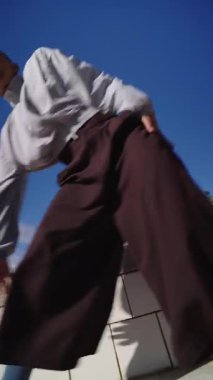 Çağdaş ve enerjik modern bir şehirde dans eden kısa saçlı yetenekli bir dansçının düşük açılı yavaş çekimi.
