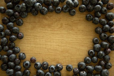 Doğal ahşap arka plan. Yemek arkaplanı. Böğürtlenler ahşap bir masada olgun ve lezzetli. Büyük bir plan, güzel bir manzara, kırsal bir tarz.