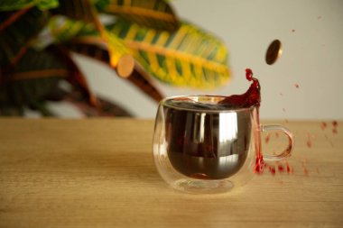 Bir bardak bardakta amber çayı. Masada çiçek ve natura.