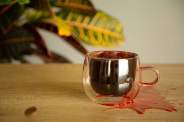 Bir bardak bardakta amber çayı. Masada çiçek ve natura.