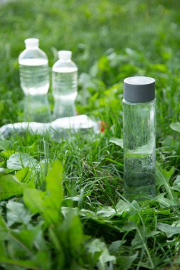 glass bottle instead of plastic water bottle, environmental protection, water splash, green grass