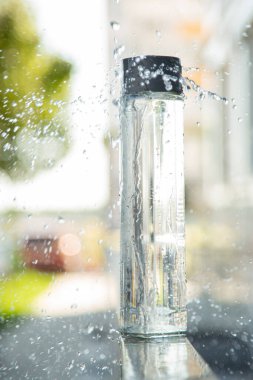 glass bottle instead of plastic water bottle, environmental protection, water splash, green grass