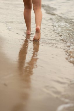 Çocuklar plaj boyunca koşar, deniz kenarında, güzel gün batımı, çocukların ayakları