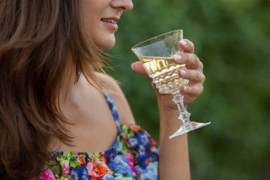 Üzüm bağında bir kız eli, günbatımı, çiçekli elbise, elinde cam ve üzüm.