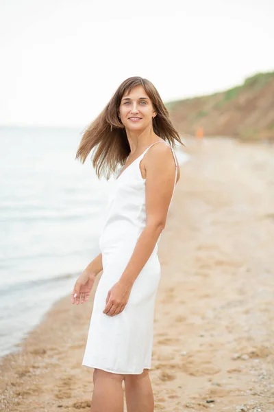 Dziewczyna Białej Sukience Plaży Pobliżu Morza Piękny Zachód Słońca Uśmiech — Zdjęcie stockowe