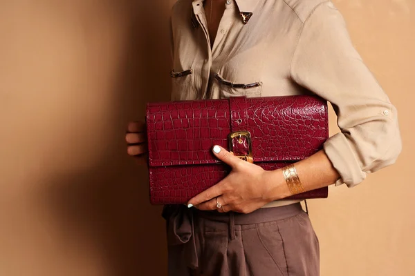 Fashionable girl wearing silk blouse holding red leather bag — Stock Photo, Image