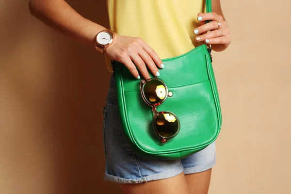 Trendy girl with green handbag clutch and sunglasses — Stock Photo, Image