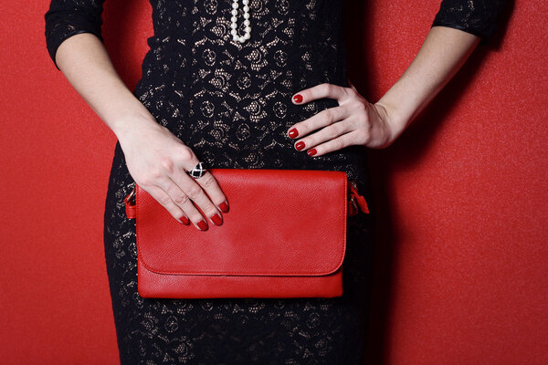 Fashionable woman with a red bag in her hands