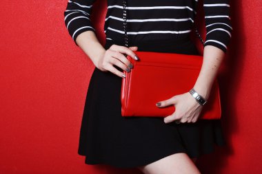 Kırmızı deri çanta tutan trendy genç kadın