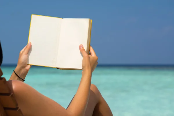 Čtení knihy v beach, ruce hospodářství kniha s prázdné stránky, — Stock fotografie