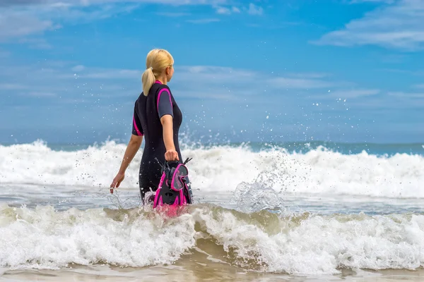 Frau mit Maske und Schwimmflossen zum Schwimmen im Hintergrund — Stockfoto