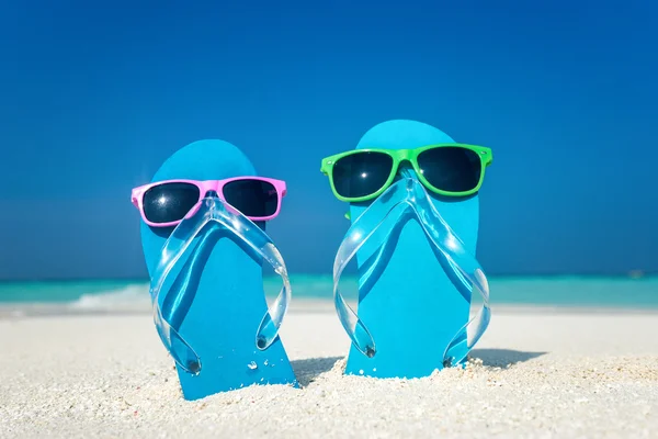 Slippers en zonnebrillen aan zee — Stockfoto