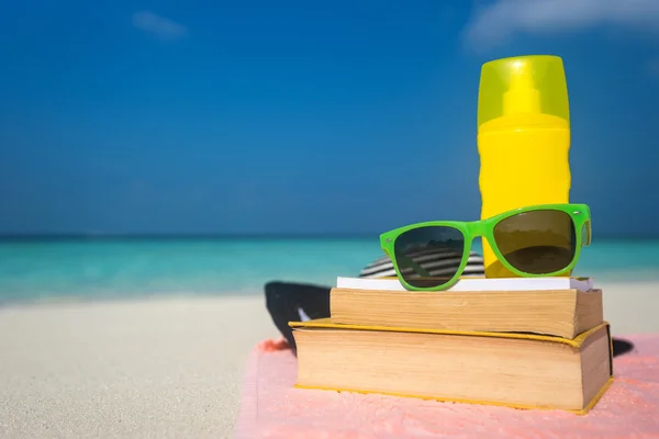 Écran solaire, chapeau et lunettes de soleil sur la plage tropicale — Photo