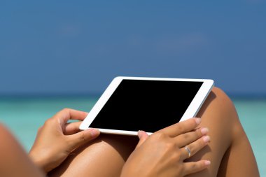 Kadınlar sahilde elinde boş boş tablet bilgisayar