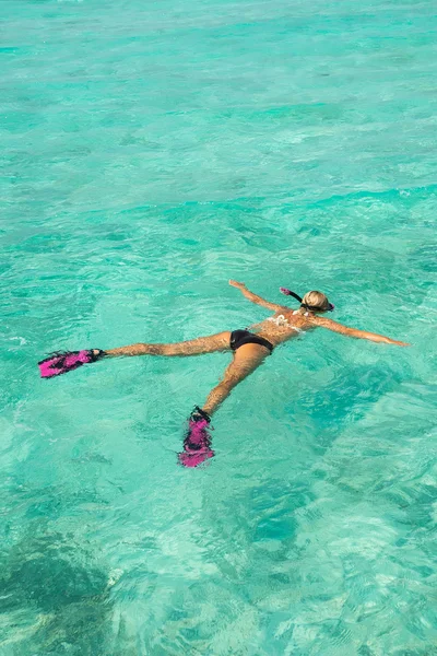 Mujer haciendo snorkel en aguas tropicales claras frente a isl exótico —  Fotos de Stock