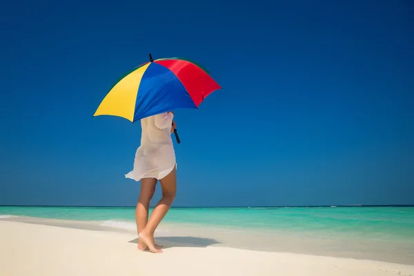 Meisje met een kleurrijke paraplu op het zandstrand — Stockfoto